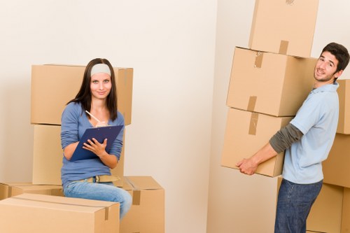 Boxes and furniture being carried through a flat hallway