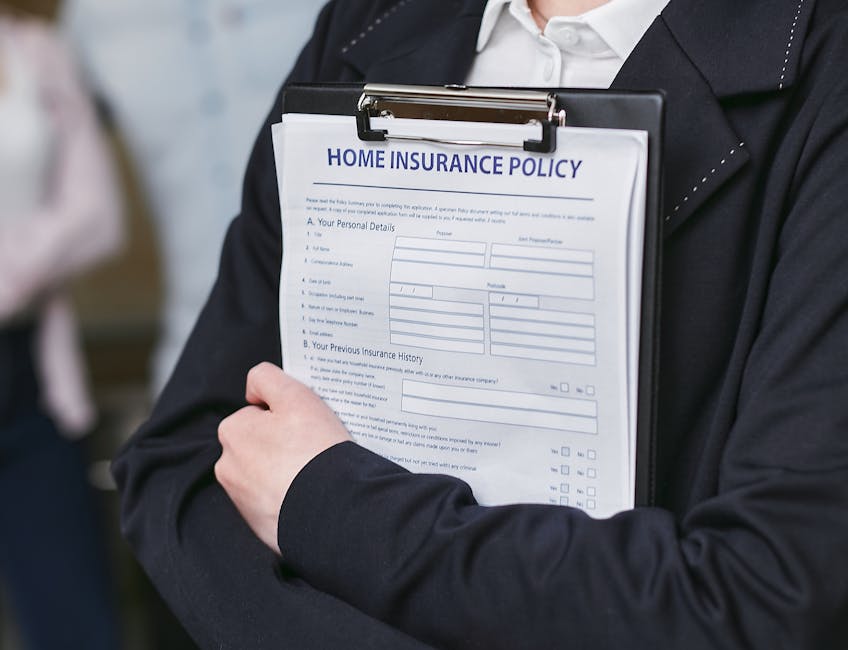 A person dressed in a dark suit jacket and white shirt is holding a clipboard with a visible home insurance policy form attached to it. The form, titled 'Home Insurance Policy,' includes sections for 